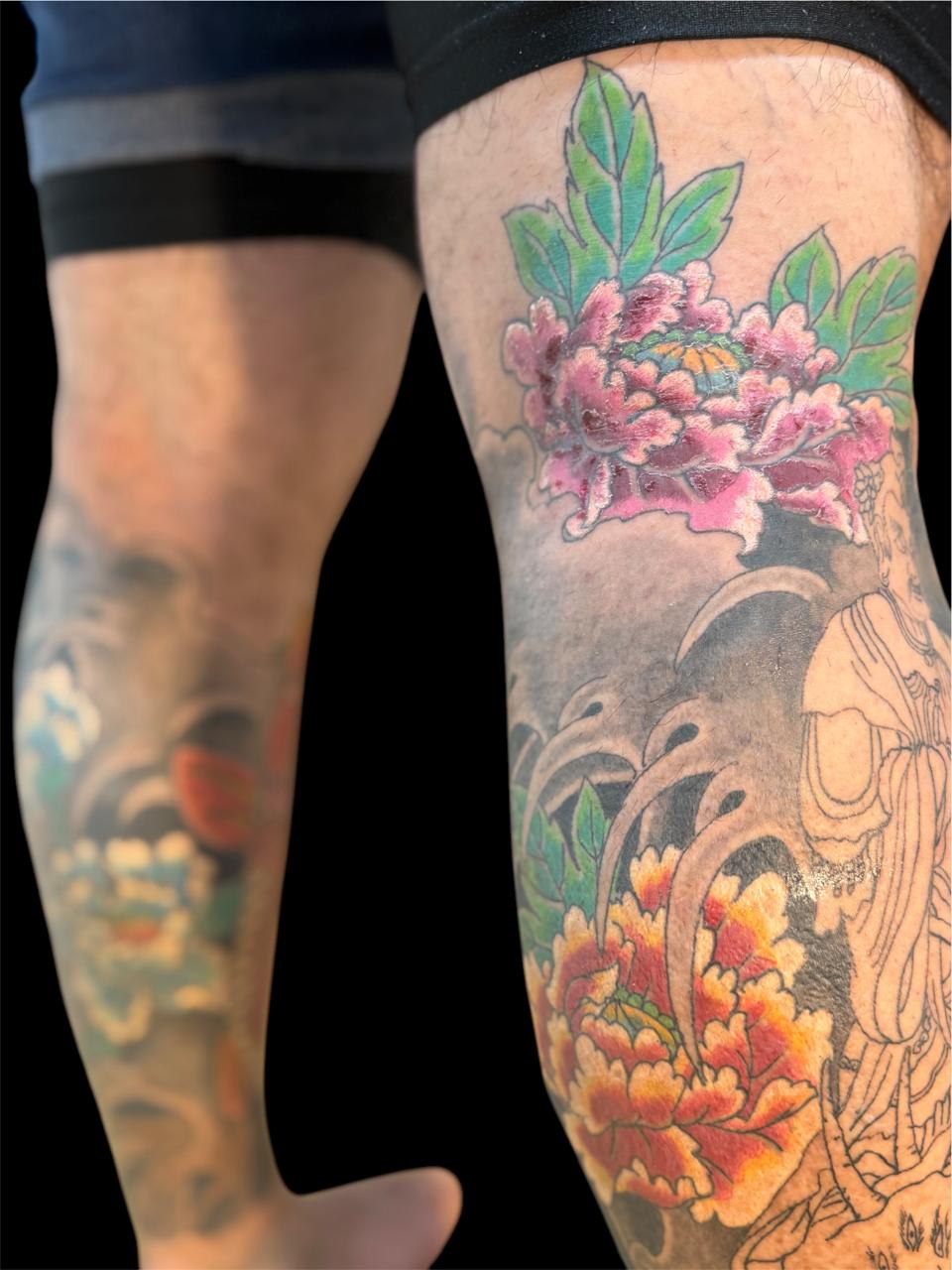 Tatuagem japonesa de peônias e figura tradicional na perna